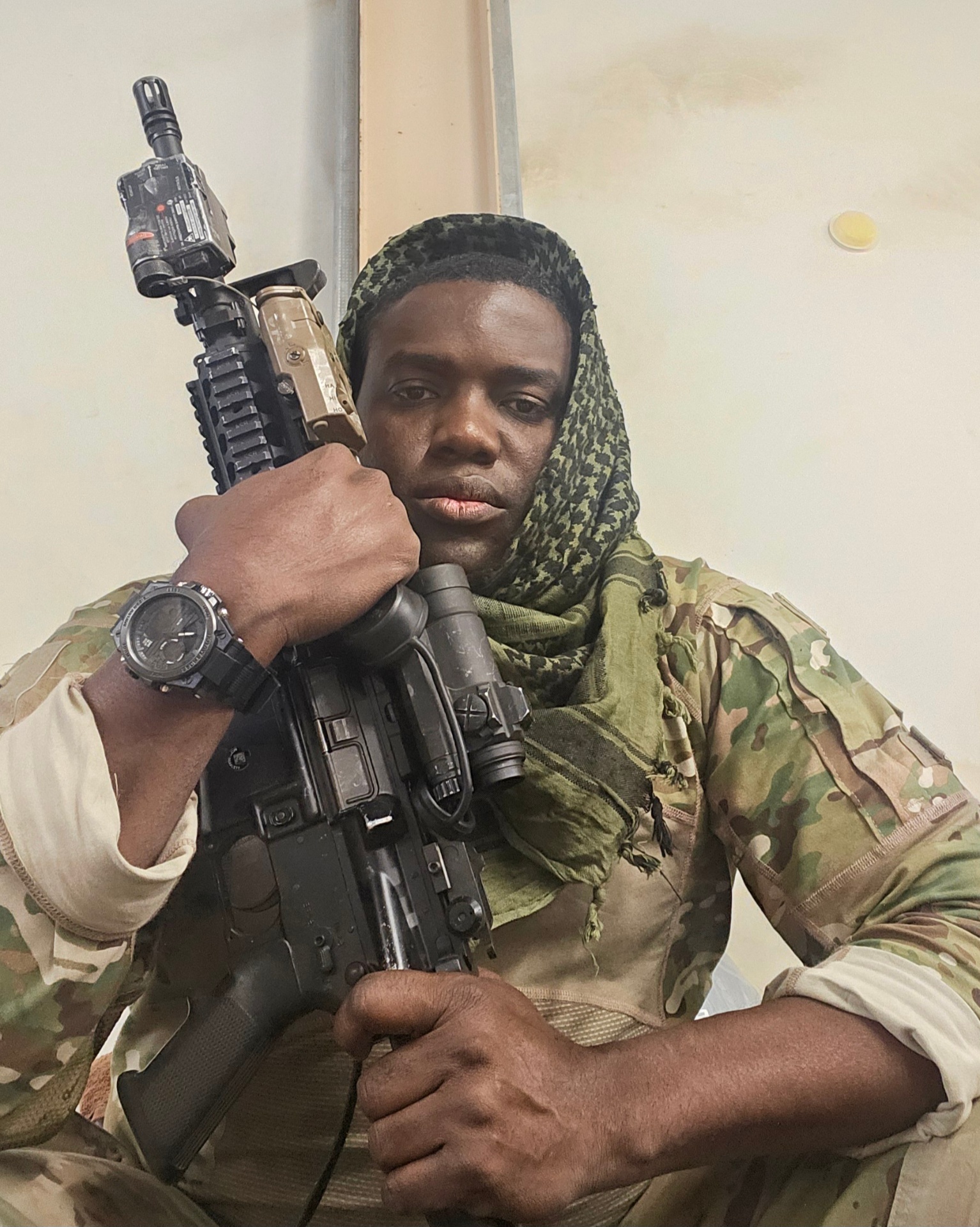 Portrait of Olardo with shemagh scarf and rifle during training