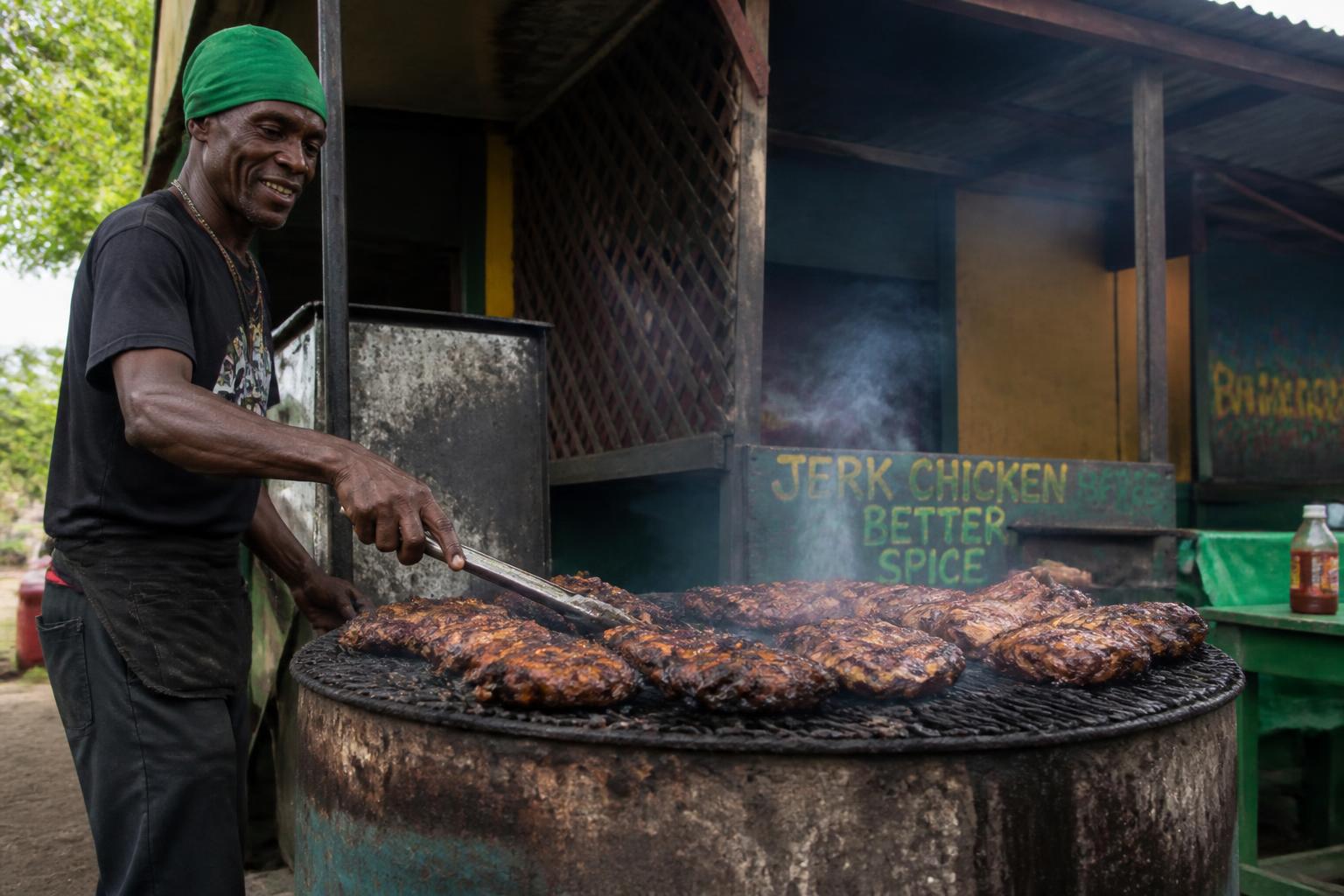 Roadside jerk chicken vendor grilling over pimento wood